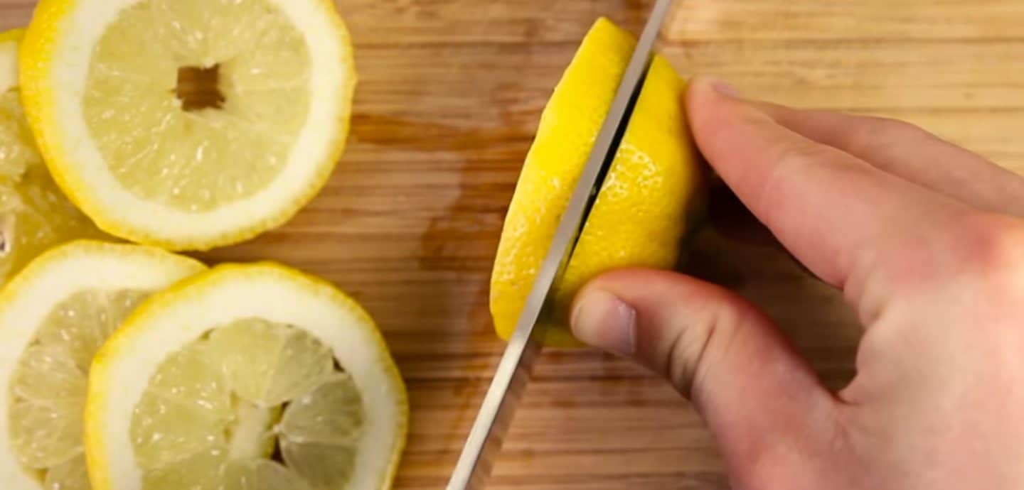 Jemand schneidet Zitronen in Scheiben