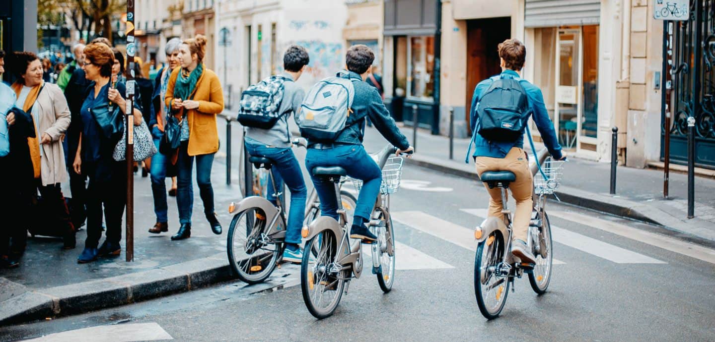 Drei Jugendliche fahren mit ihrem Fahrrad um eine Ecke