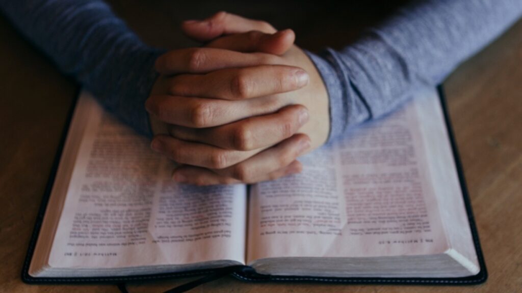 Betende Hände auf Bibel