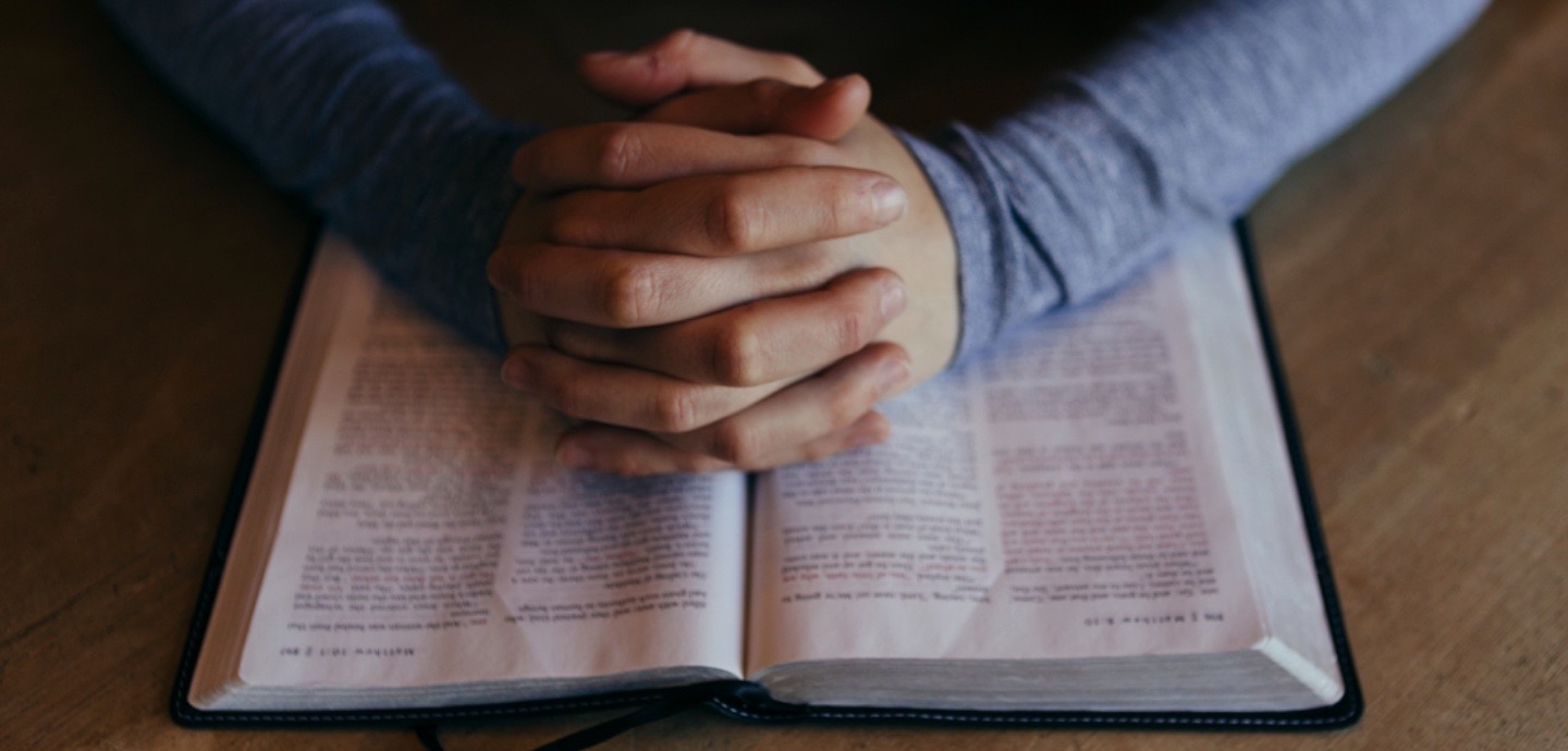 Betende Hände auf Bibel