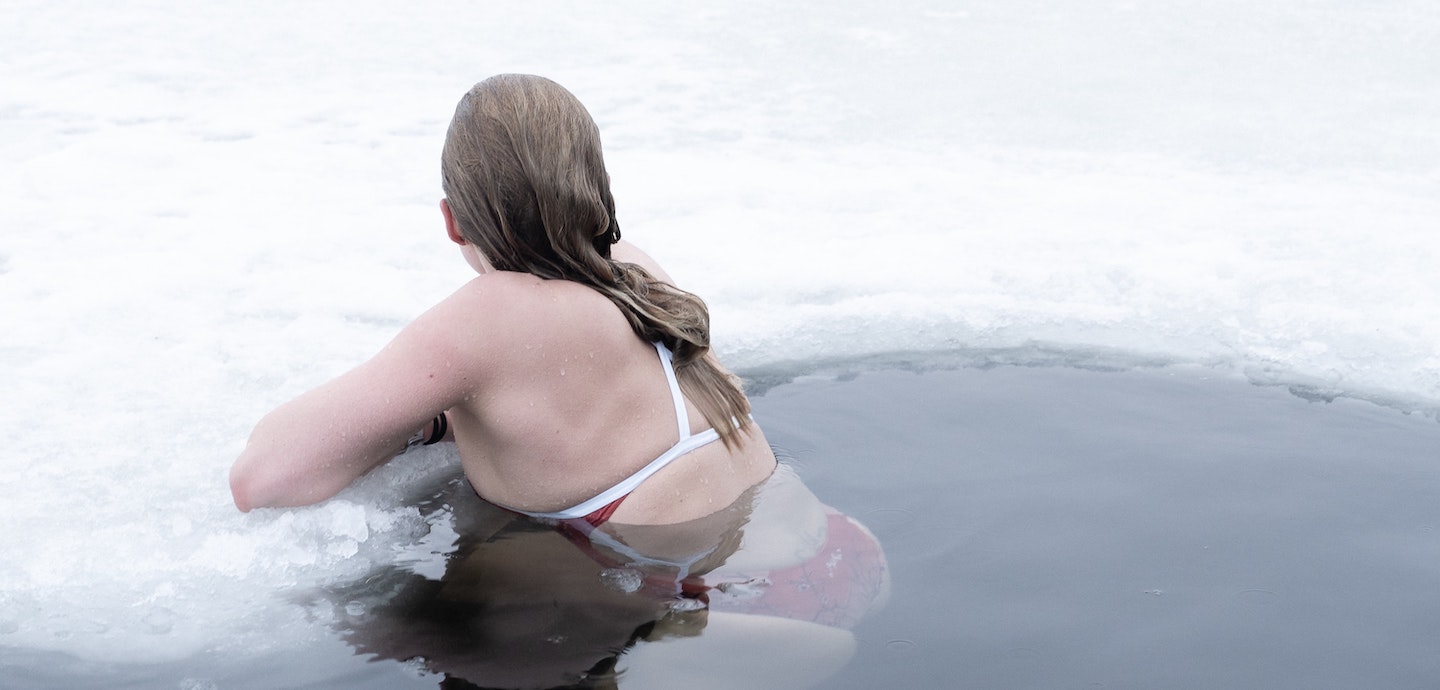 Frau badet in Eisloch