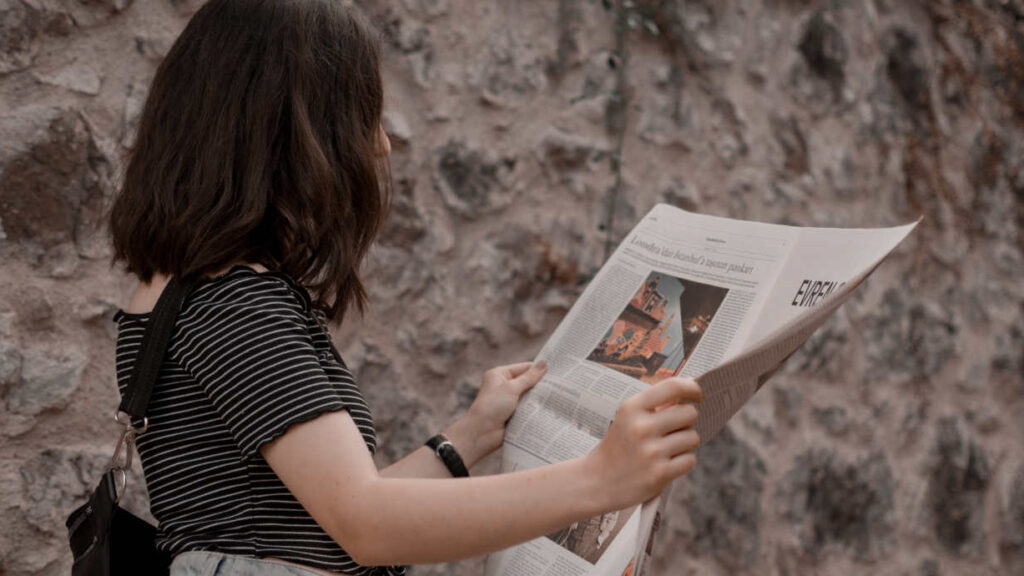 Eine junge Frau liest Zeitung