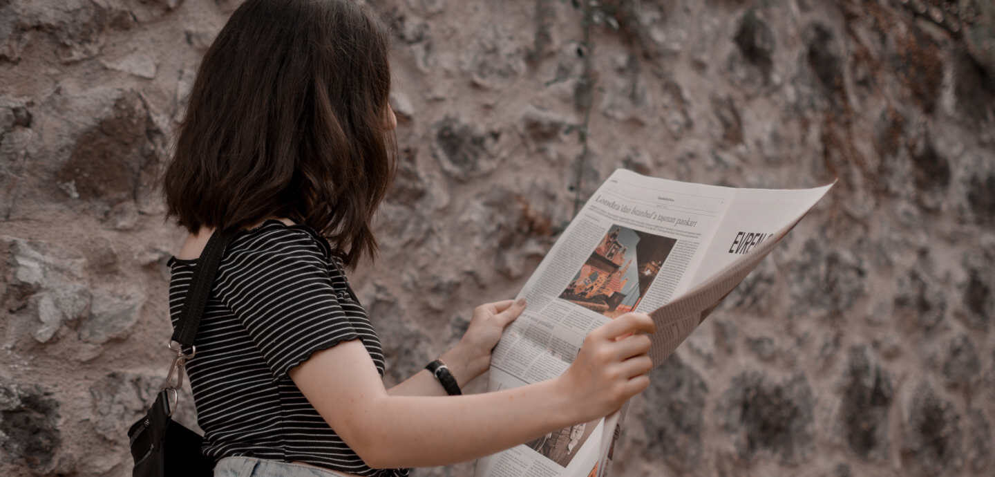 Eine junge Frau liest Zeitung