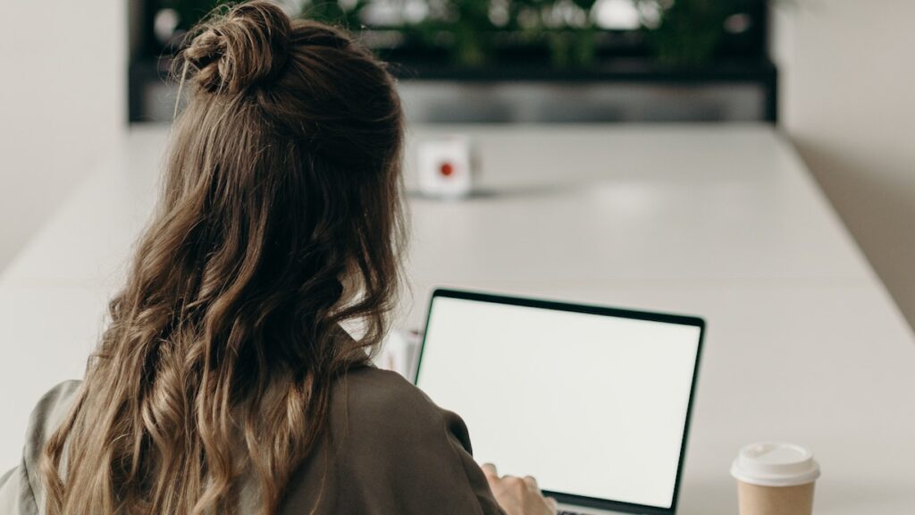 Eine junge Frau arbeitet am Laptop.