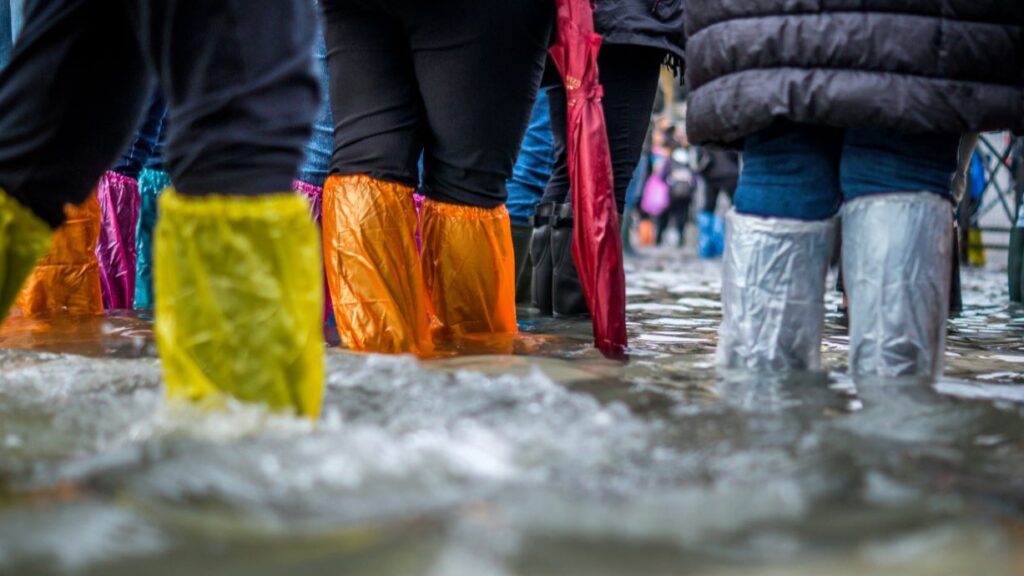 Mit bunten Plastiktüten überzogene Waden stehen im Hochwasser.