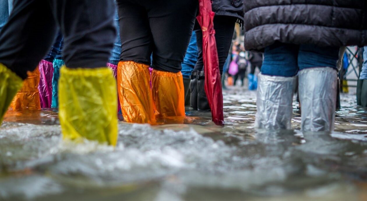 Mit bunten Plastiktüten überzogene Waden stehen im Hochwasser.